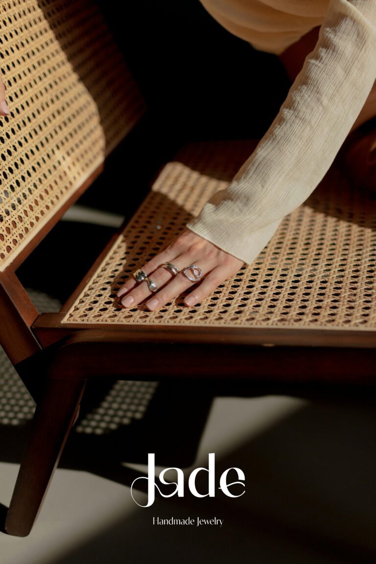 Feminine jewelry logo design for Jade, a handmade jewelry brand, featuring soft curves inspired by ring shapes and the natural lines of women’s bodies, expressing craftsmanship, elegance, and empowerment.