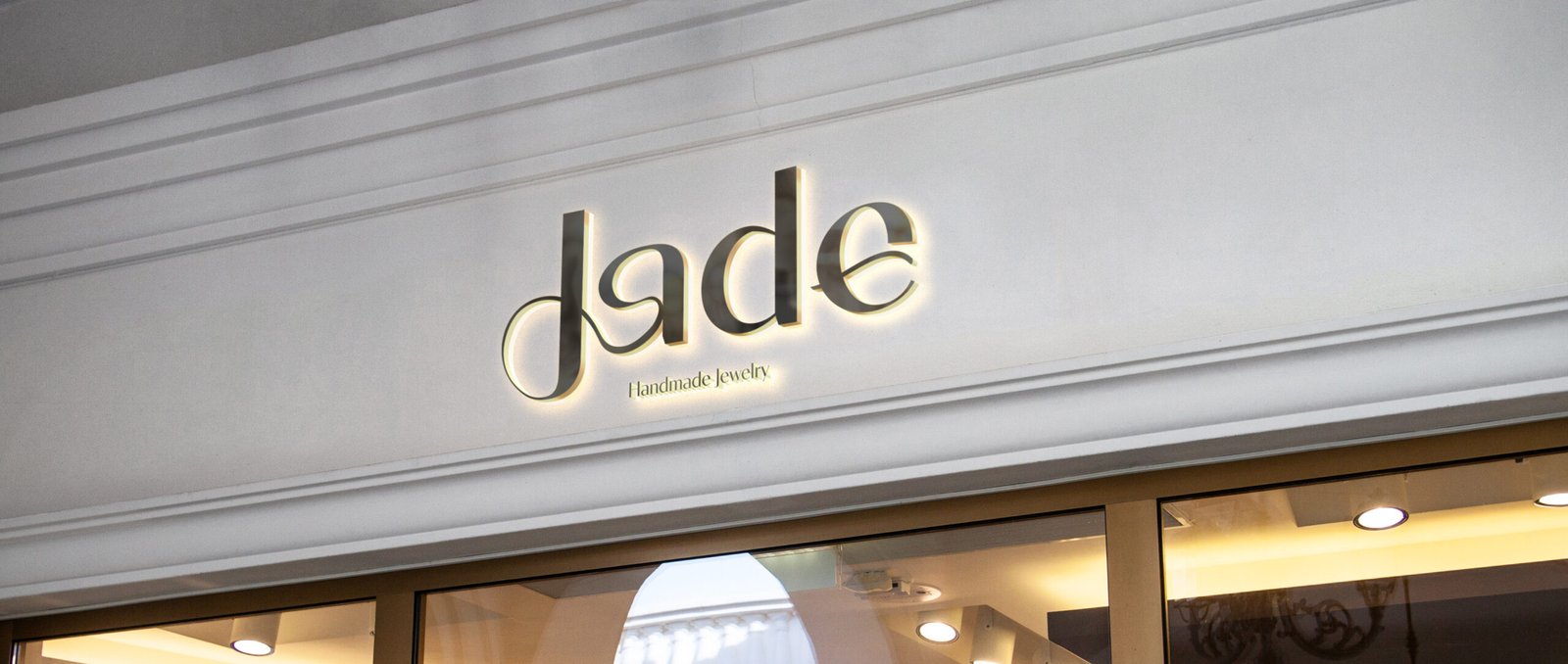 Feminine jewelry logo design for Jade, a handmade jewelry brand, featuring soft curves inspired by ring shapes and the natural lines of women’s bodies, expressing craftsmanship, elegance, and empowerment.