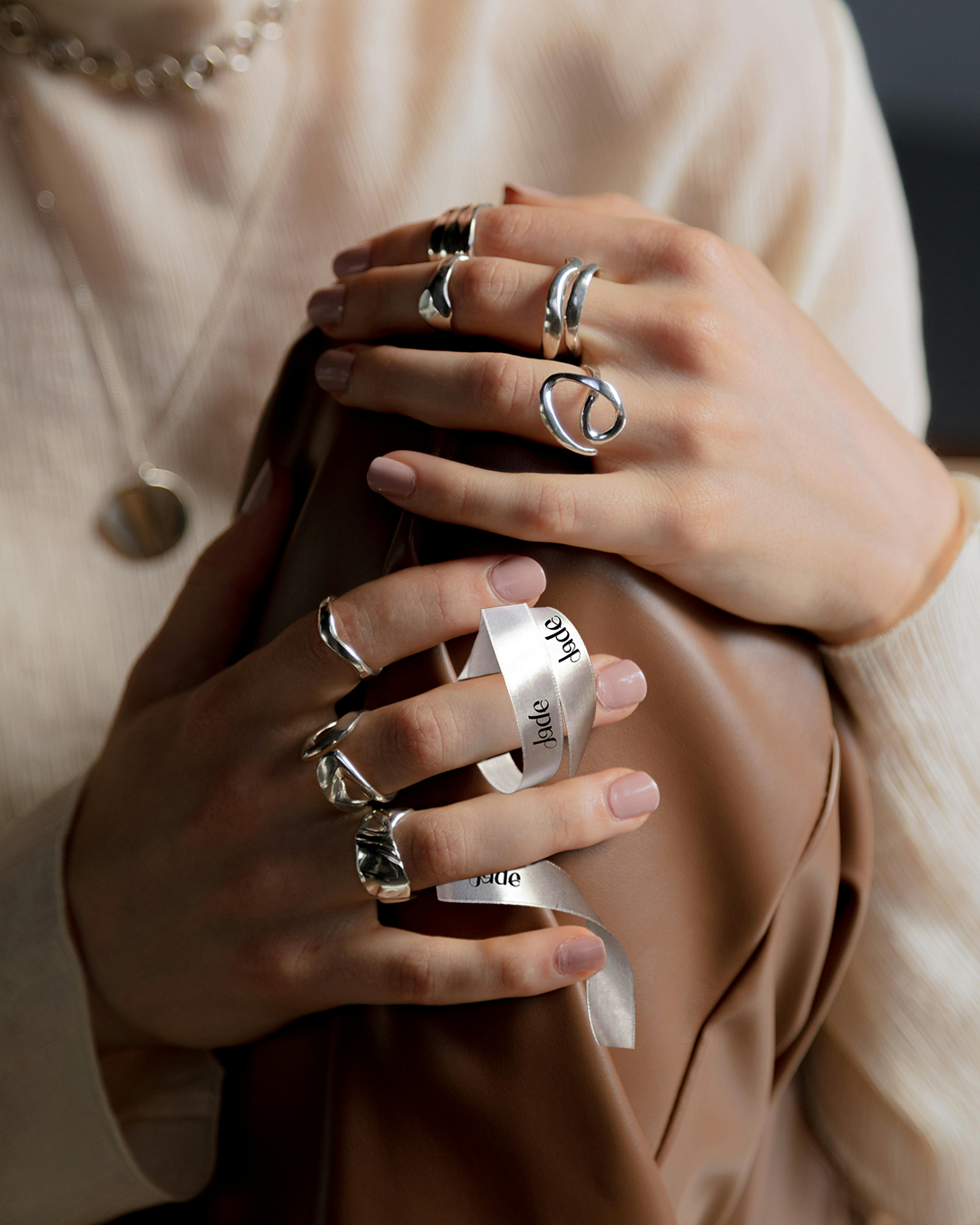 Feminine jewelry logo design for Jade, a handmade jewelry brand, featuring soft curves inspired by ring shapes and the natural lines of women’s bodies, expressing craftsmanship, elegance, and empowerment.