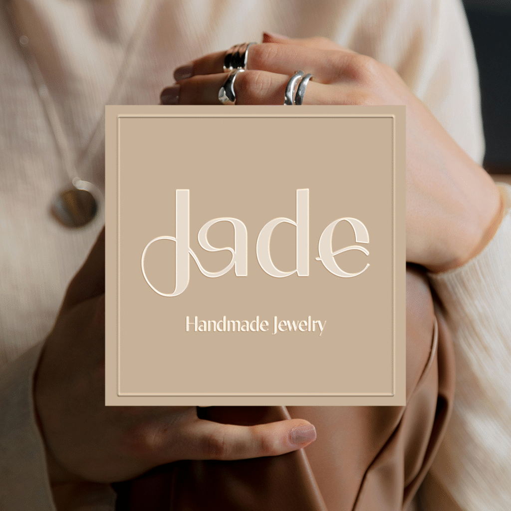 Feminine jewelry logo design for Jade, a handmade jewelry brand, featuring soft curves inspired by ring shapes and the natural lines of women’s bodies, expressing craftsmanship, elegance, and empowerment.